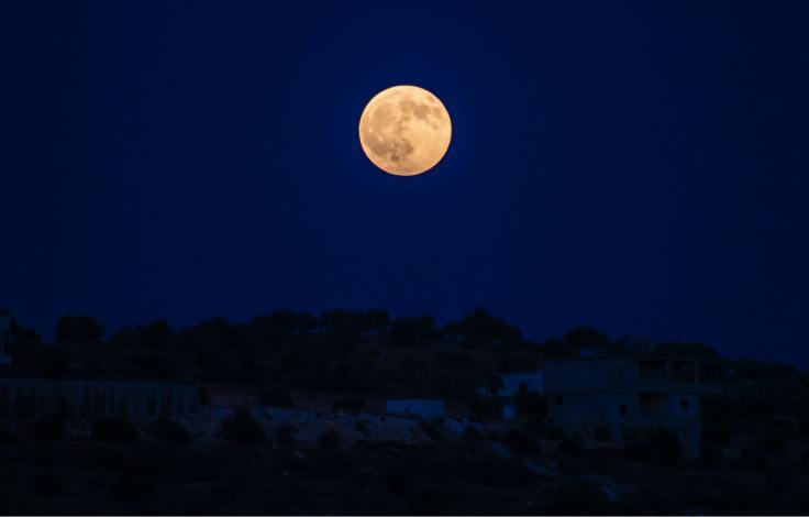 Full moon at night over a town